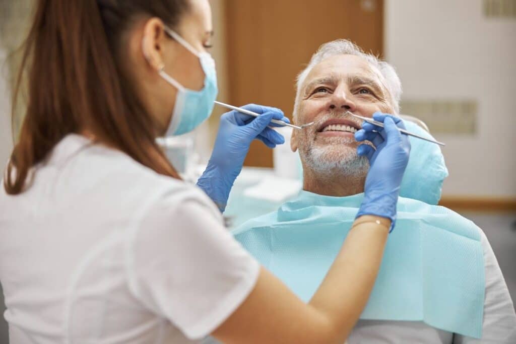 Senior man smiling during dental examination with dentist in Magnolia, TX.